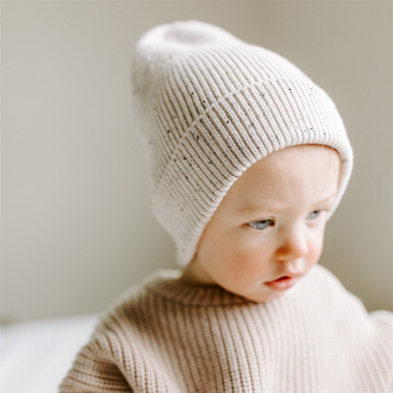 Speckled cotton knit hat for babies, featuring a soft ribbed design in a stylish, gender-neutral color. Ideal for keeping little heads and ears warm during colder months.