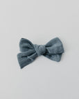 Handmade linen bow in soft clay color, attached to an alligator clip, perfect for adding a stylish touch to any outfit. 