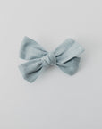 Handmade linen bow in soft clay color, attached to an alligator clip, perfect for adding a stylish touch to any outfit. 