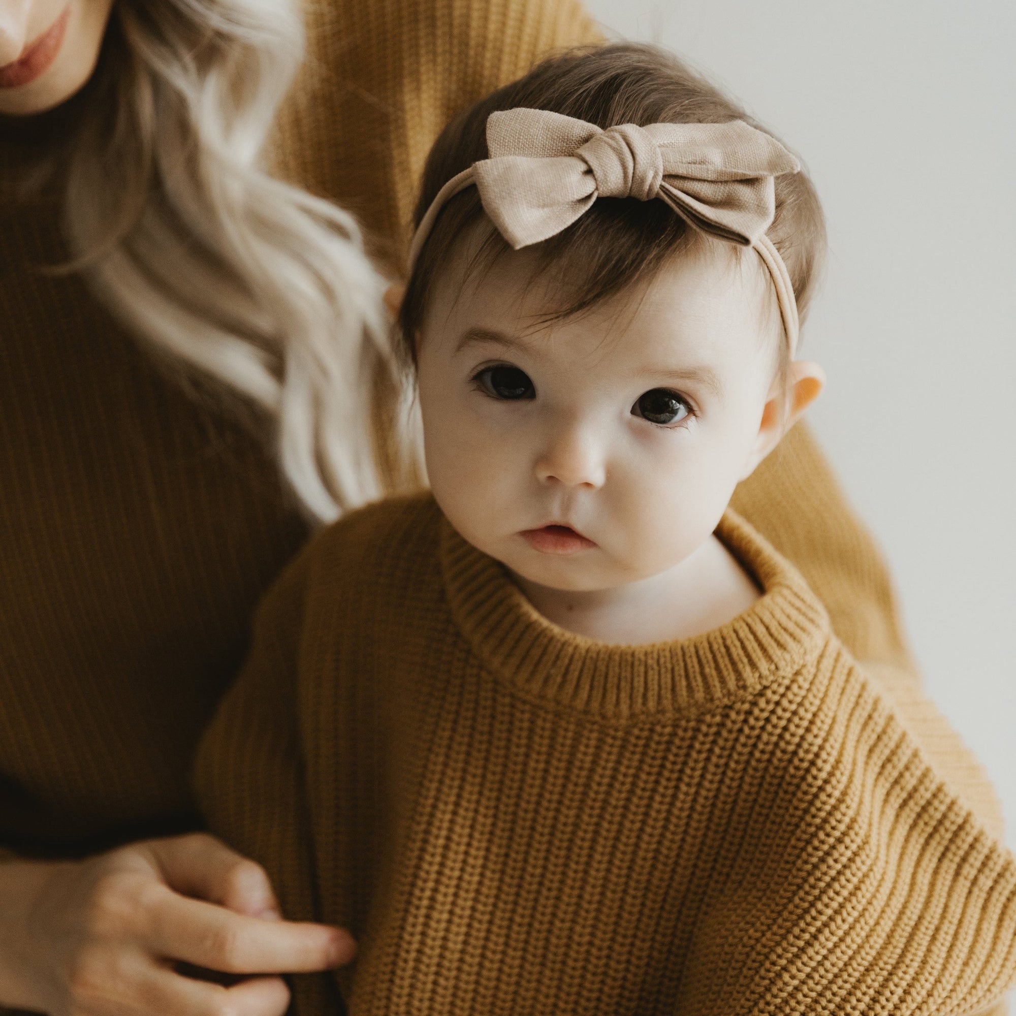 Handmade linen bow in soft clay color, attached to an alligator clip, perfect for adding a stylish touch to any outfit. 